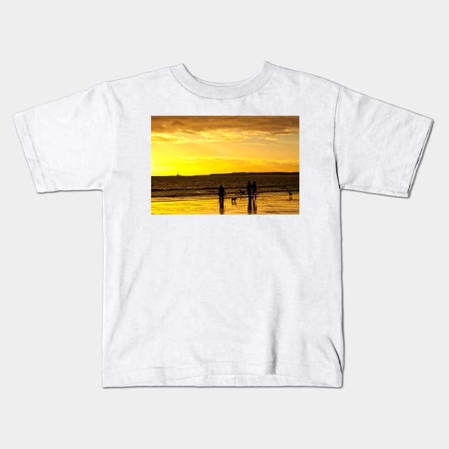 Dog walkers on the beach at sunrise Kids T-Shirt by Violaman